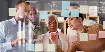 Individuals looking at post its on board